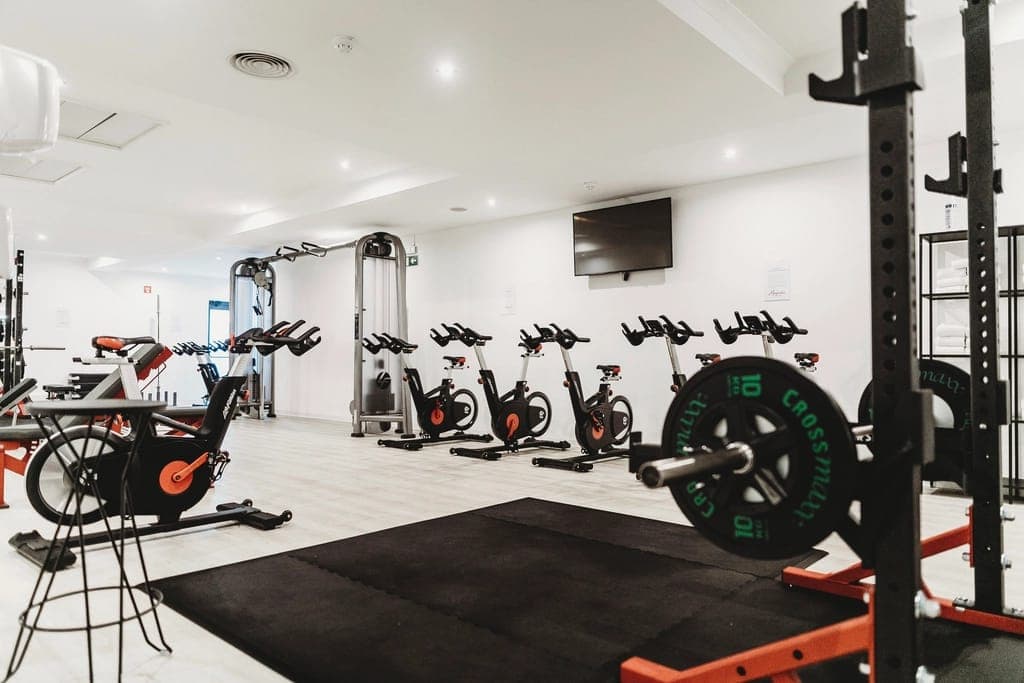 Sala com bicicletas de spinning e racks de peso