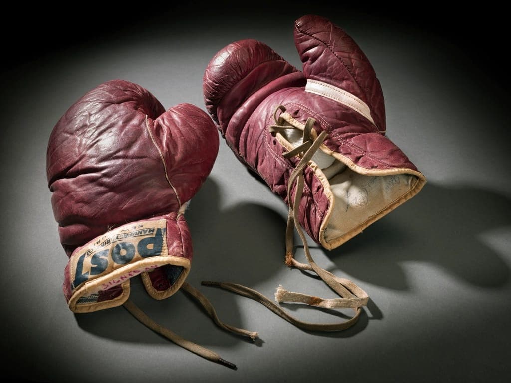 Par de luvas de boxe vermelhas, gastas pelo uso