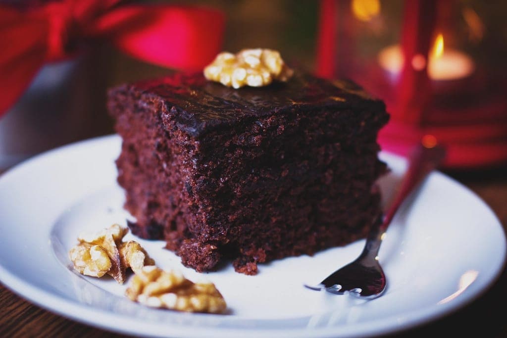 Fatia de bolo de chocolate com nozes sobre prato branco