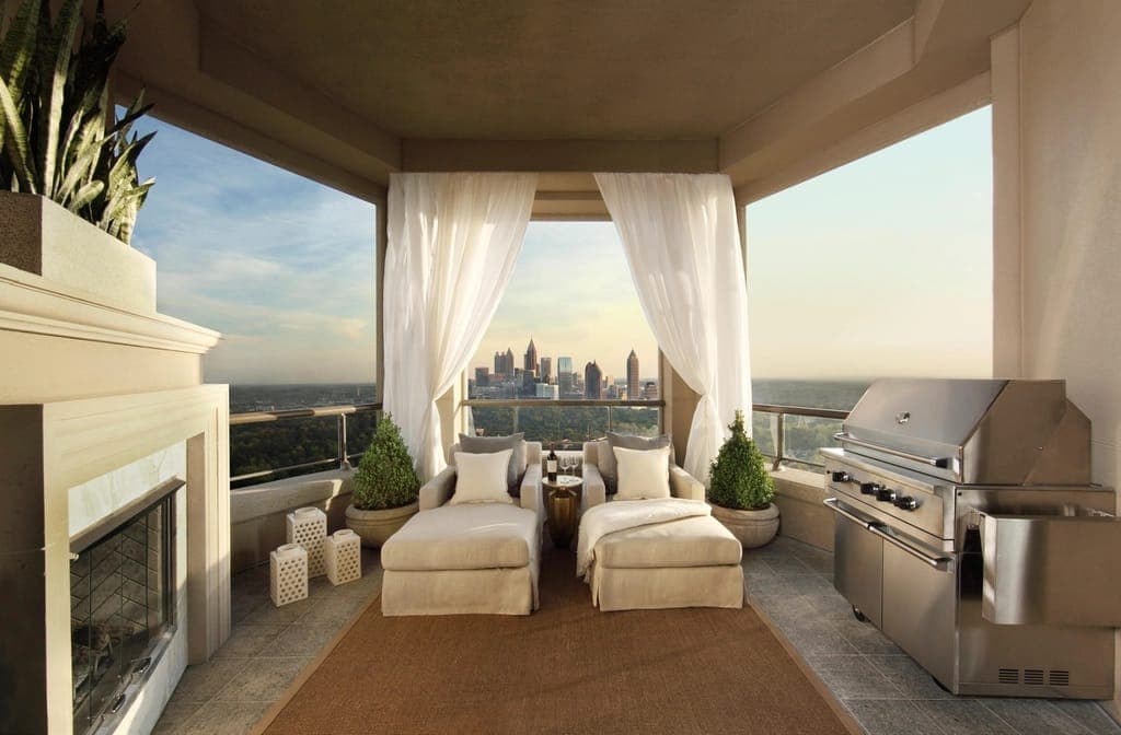 Terraço de cobertura com cortinas brancas e vista da cidade