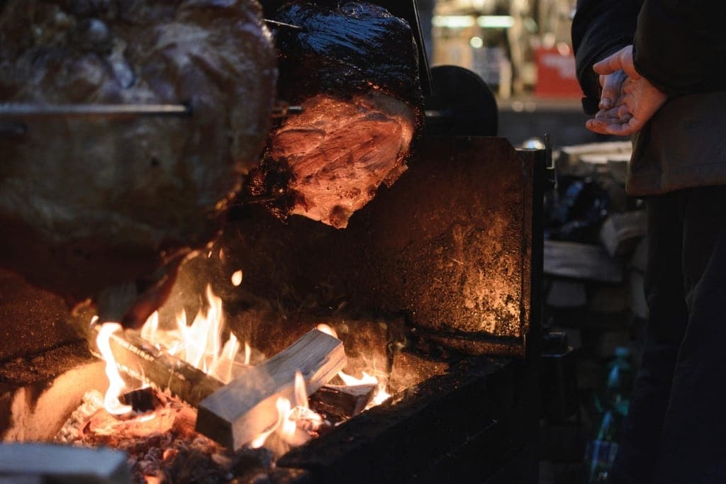 Carne assando sobre fogo de lenha